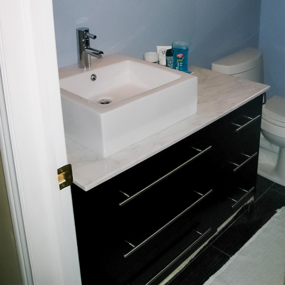 Dark Vanity with quartz top and vessel style white sink