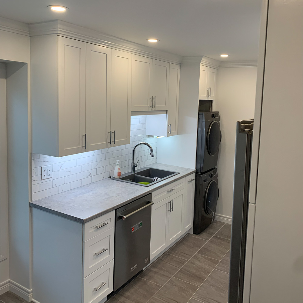 White Shaker Kitchen with Built-in Laundry Unit.