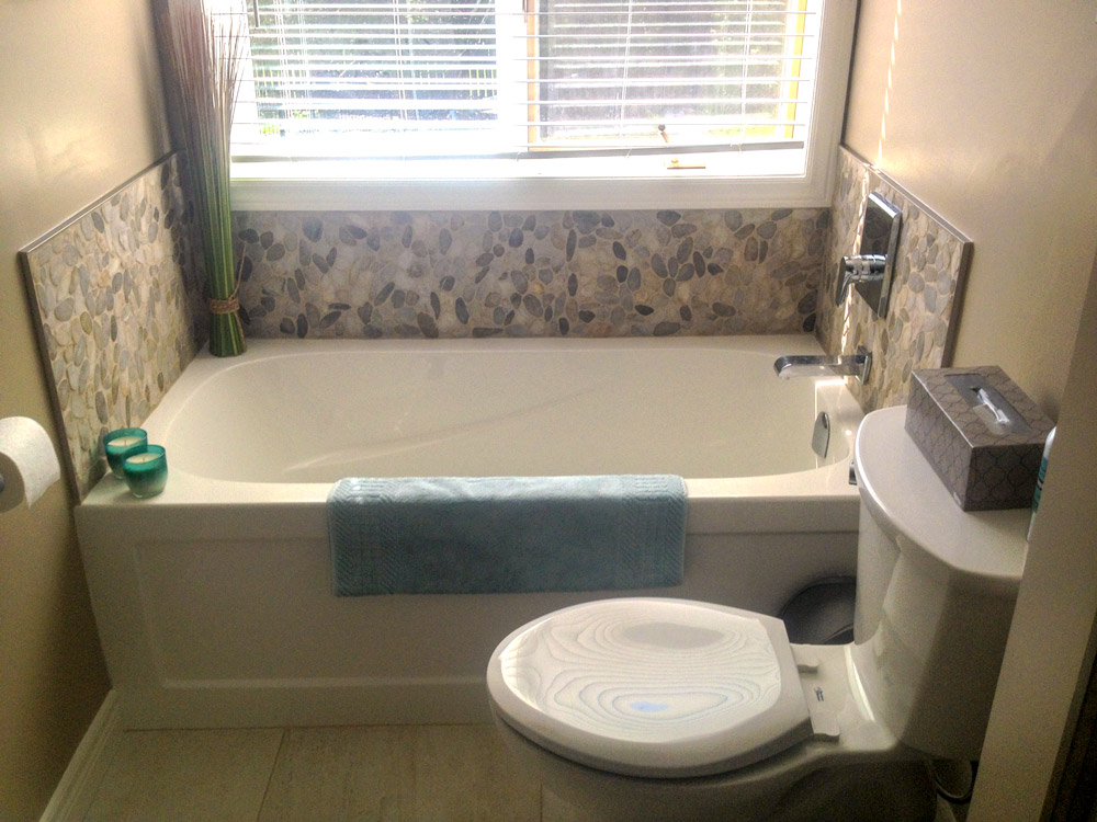 Alcove skirted tub with custom rock tile moasic surround.